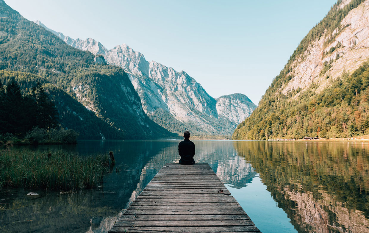 Man sitting on grey dock Man sitting on grey dock